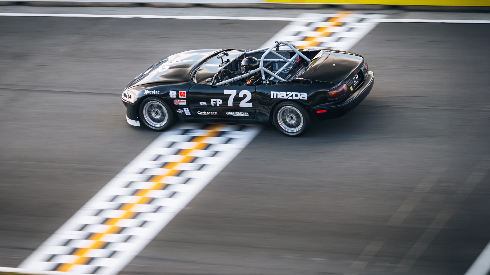 Mazda Race Car Crossing the Finish Line on a Track