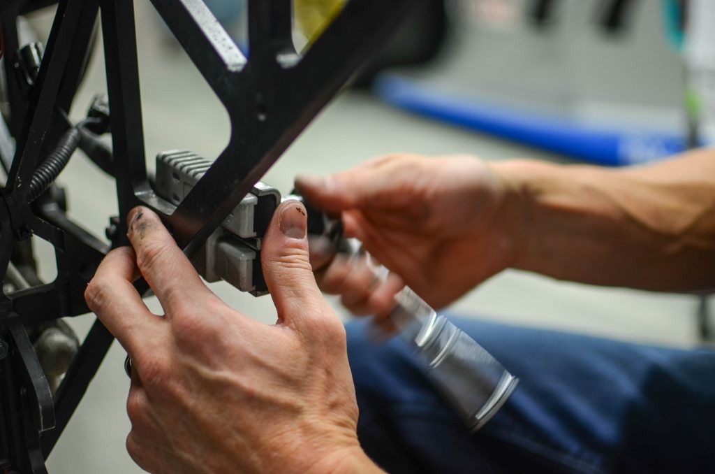 Hands working on a Mazda vehicle