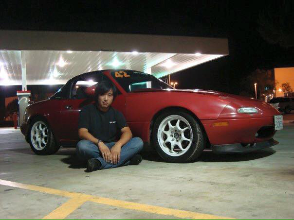 Daniel Lim Sitting Next to Red Mazda MX-5 Miata