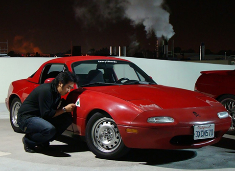 Daniel Lim Kneeling Next to Red Mazda MX-5 Miata