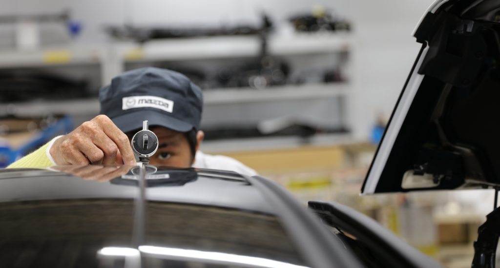 Mazda engineer Takaki Nakamura taking measurements on a new vehicle