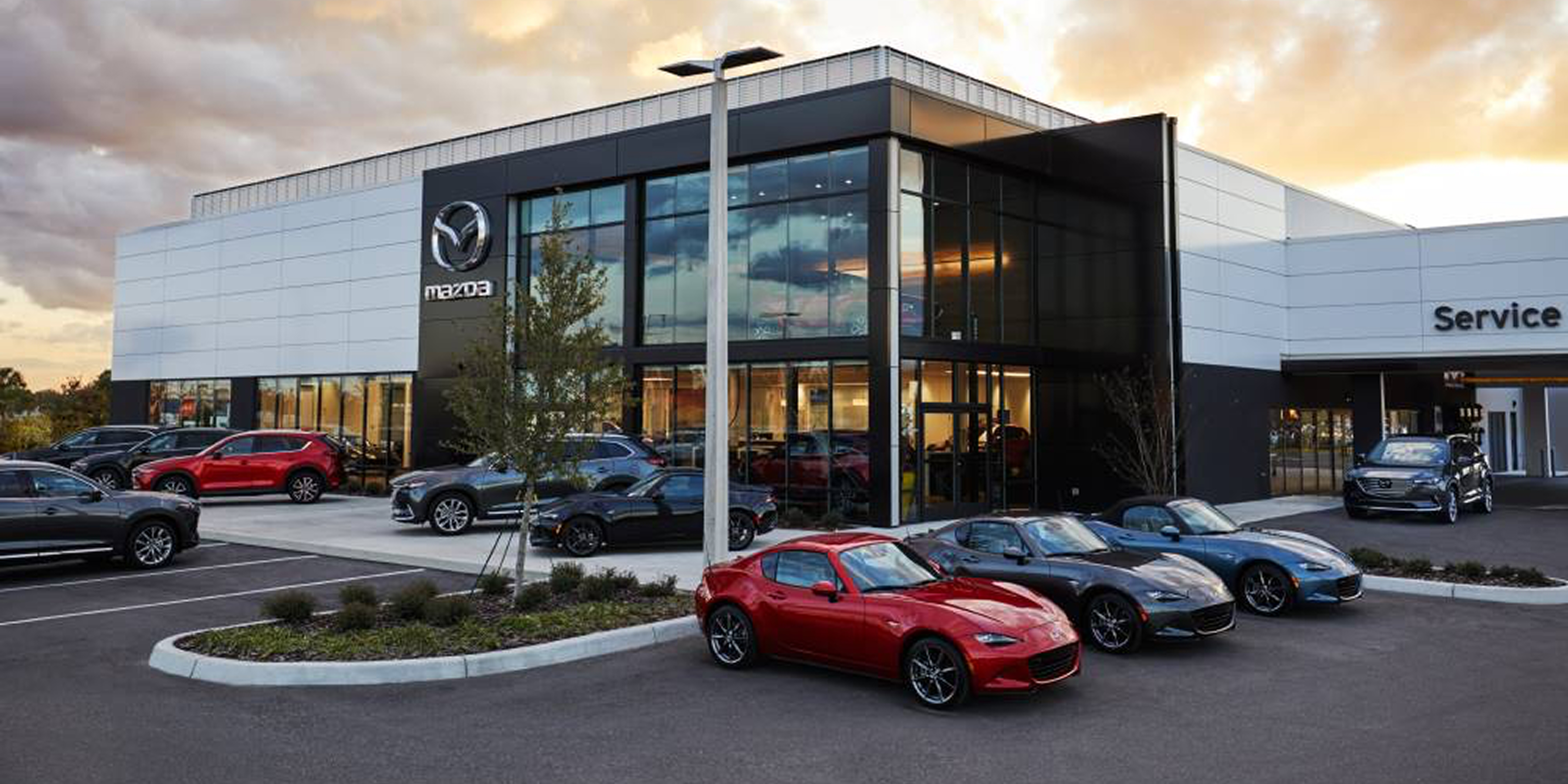 Exterior shot of Mazda dealership with multiple vehicles parked outside